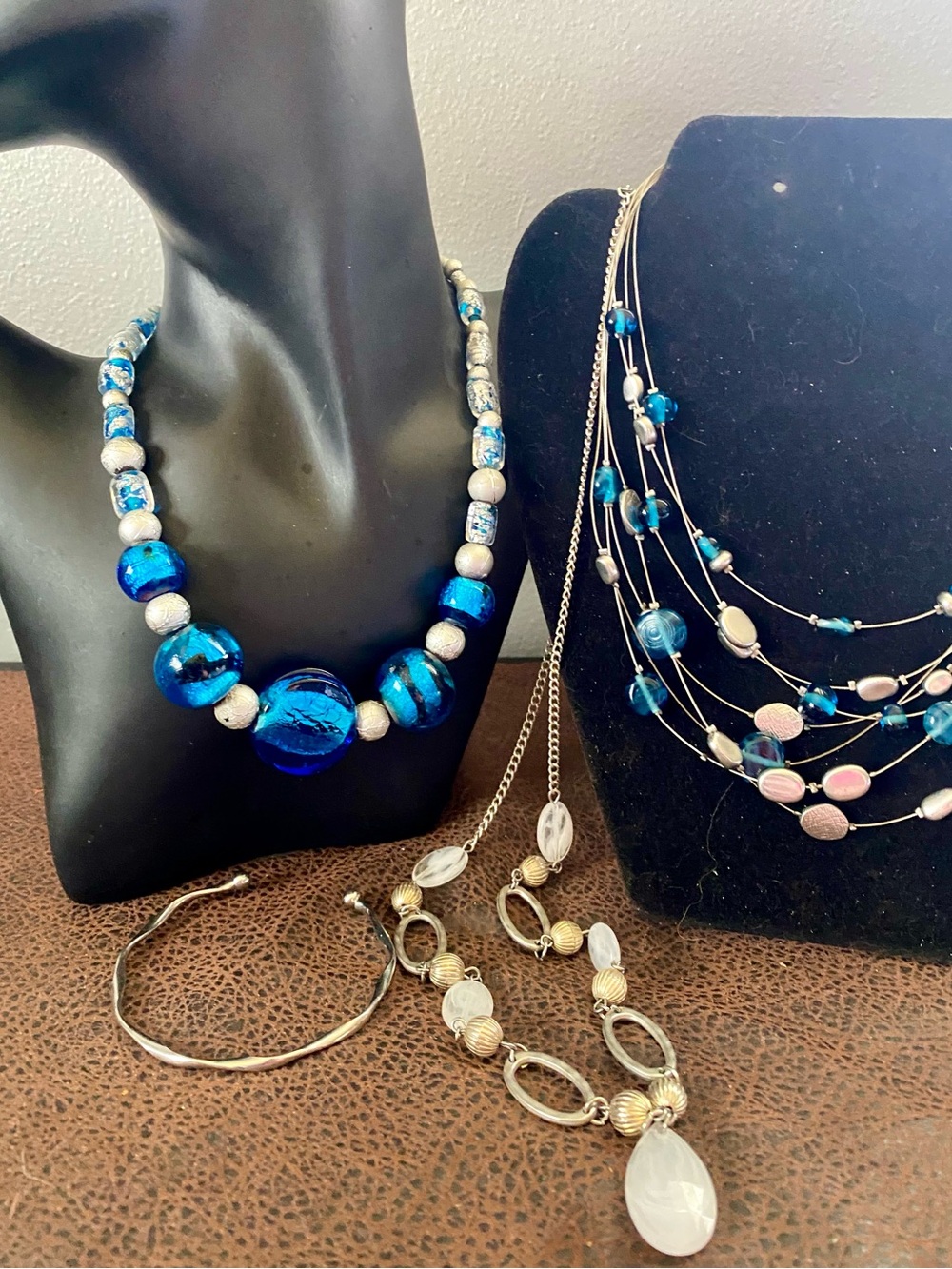 Vibrant mix of blue glass, silver accents, and statement necklaces and bracelets